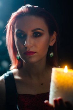 Gizemli büyü yakın plan, siyah arka planda izole bir şekilde yanan mumun üzerinde sihirbazlık yapan kadın. Kehanet, kehanet ve kehanet kavramı..