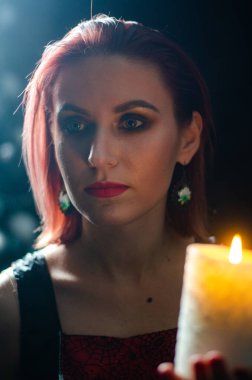 Gizemli büyü yakın plan, siyah arka planda izole bir şekilde yanan mumun üzerinde sihirbazlık yapan kadın. Kehanet, kehanet ve kehanet kavramı..