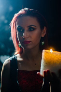 Gizemli büyü yakın plan, siyah arka planda izole bir şekilde yanan mumun üzerinde sihirbazlık yapan kadın. Kehanet, kehanet ve kehanet kavramı..