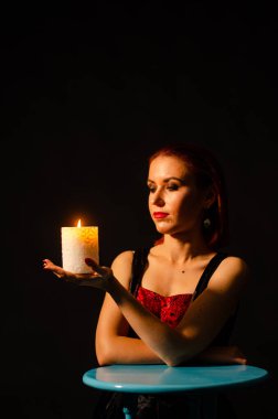 Gizemli büyü yakın plan, siyah arka planda izole bir şekilde yanan mumun üzerinde sihirbazlık yapan kadın. Kehanet, kehanet ve kehanet kavramı..