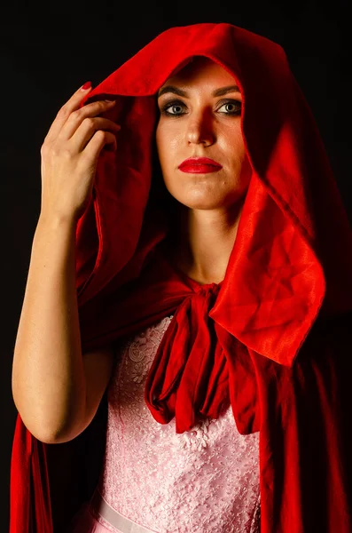 工作室里穿着红色斗篷的漂亮女人 女人红帽 戏剧化和精彩的拍摄 时尚色调 像个公主 — 图库照片