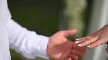 Damat gelinlerin parmağına nişan yüzüğü takıyor.