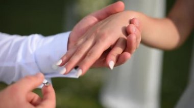 Damat gelinlerin parmağına nişan yüzüğü takıyor.