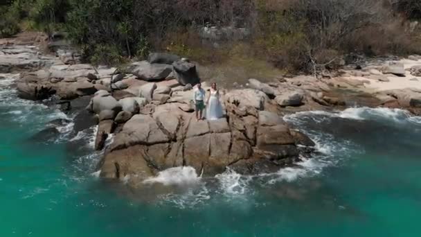 Un ragazzo e una ragazza sono in piedi sulle rocce in un abbraccio — Video Stock