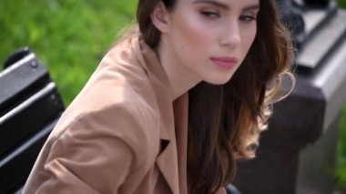 Bir yaz gününde, tasarımcı elbise giymiş bir kız sokakta yürürken yüzünde makyaj ile genç kadın