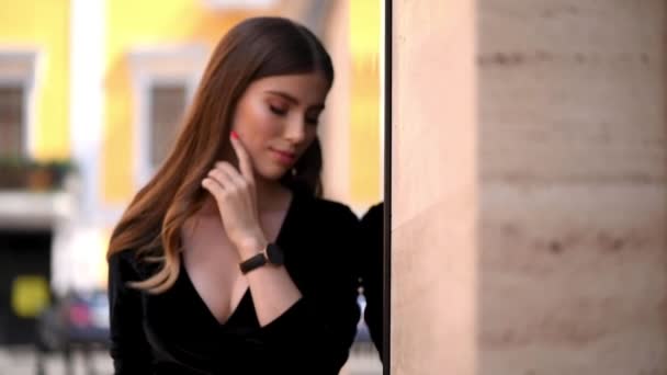 Jonge vrouw met make-up op haar gezicht lopend onderaan de straat op een zomerdag, een meisje gekleed in een designer jurk — Stockvideo
