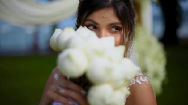 Noiva Senta Junto Arco Casamento Gramado Verde Fareja Toca Suas — Vídeo de Stock
