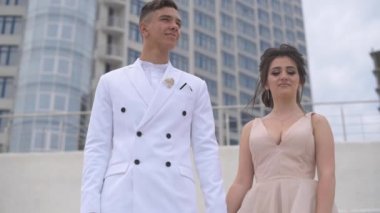 İkisi akşam kıyafetleri giyen adam merdivenlerde ve denize bakıyor.
