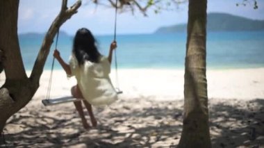 tropikal bir adada bir salıncak kız sürmek