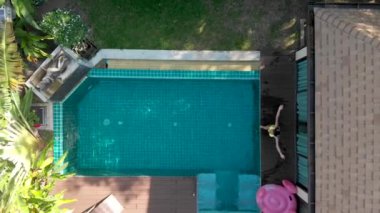 pembe flamingo kız havuzda yüzer