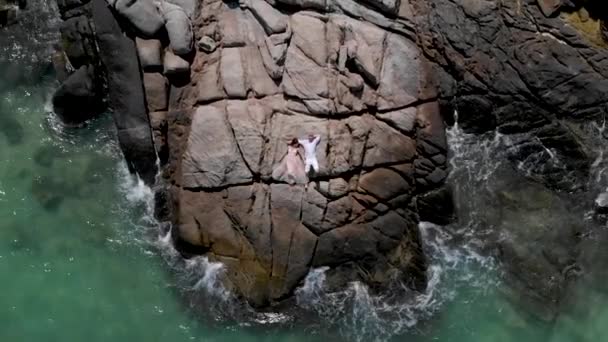 男孩和女孩躺在岩石上 在海洋的悬崖上 — 图库视频影像