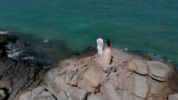 男と少女が海の向けの岩の上に立つ — ストック動画