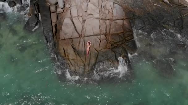 女孩躺在海边的岩石上 — 图库视频影像