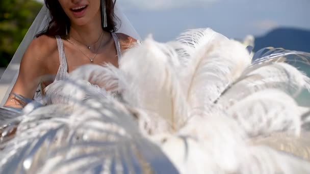 Girl posing in white feather scenery — Stock Video