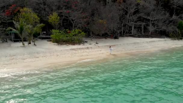 一个穿白色衣服的女孩在海边的海滩上盘旋 — 图库视频影像