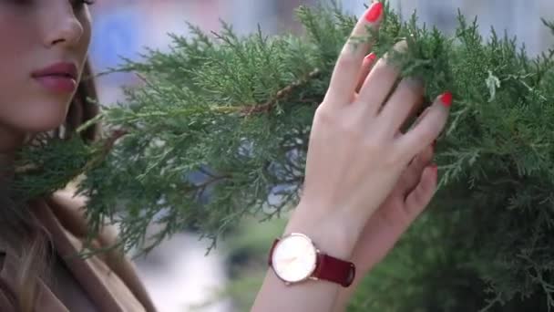 Mujer joven con maquillaje en la cara caminando por la calle en un día de verano, una chica vestida con un vestido de diseñador — Vídeos de Stock