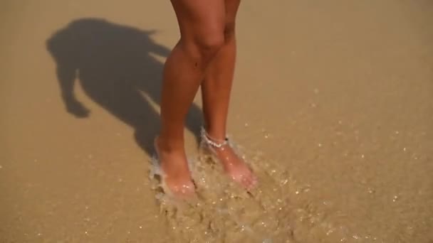 Красиві Таніровані Ноги Йдуть Уздовж Піску Біля Моря Миючи Хвилями — стокове відео