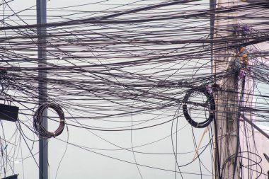 Bu görüntü, şehir ortamında karmaşık kablo ve kablolardan oluşan bir dizi yakalar ve modern bağlantıların karmaşıklığını gösterir..