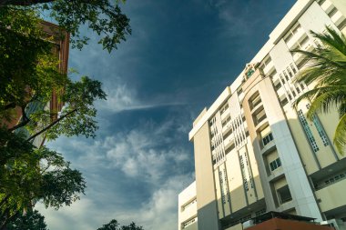 Temiz bir gökyüzü ve yemyeşil ile modern mimarinin çarpıcı bir görüntüsü. Bu görüntü kentsel tasarımın özünü yakalar, doğa ve yapıyı harmanlar..