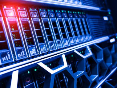 Bu detaylı yakın çekim resmi, bir veri merkezinde gelişmiş teknolojiyi temsil eden, aktif sürücüleri vurgulayan yeşil LED göstergeleri olan modern bir sunucu rafını gösteriyor..