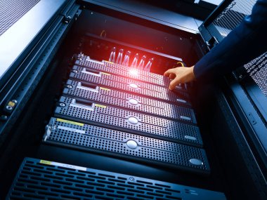 Bir teknisyen modern veri merkezi rafında sunucu bakımını gerçekleştirir, hayati bilgisayar ekipmanları için optimum performans ve bağlantı sağlar.