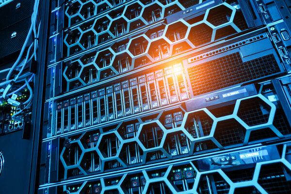 This image showcases a modern server rack within a data center, featuring intricate network equipment and blue LED lighting, highlighting IT infrastructure.