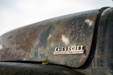 Klasik Amerikan otomotiv mirasını ve nostaljisini temsil eden paslı ve yıpranmış dokusunu sergileyen klasik Chevrolet Thriftmaster kamyonunun yakın plan çekimi..