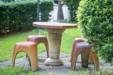 Ahşap taburelerle çevrili kırsal bir bahçe masası açık hava oturma alanı yaratıyor. Yeşillik ve sükunetin ortasında rahatlamak için mükemmel..