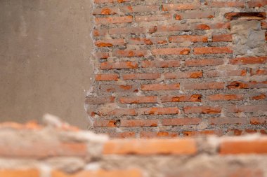 Eşsiz doku ve renkleri gösteren açıkta kalmış tuğla bir duvarın yakından görüntüsü. Kırsal unsurlar inşaat bağlamında mimari ayrıntıları vurguluyor.