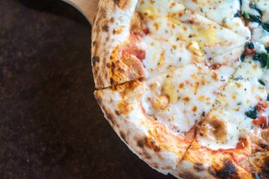 Çıtır kıtır ve erimiş mozzarella içeren cazip bir peynirli pizza dilimi. Paylaşmak için mükemmel, bu lezzetli yemek geleneksel İtalyan lezzetlerini ön plana çıkarıyor..