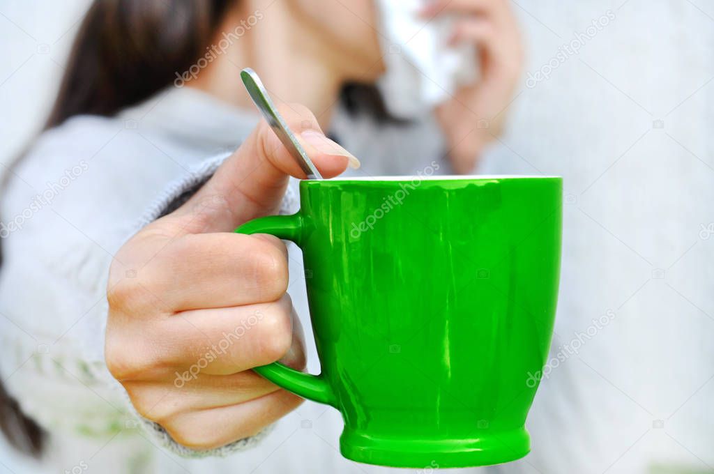 Flu. Young woman got nose allergy, flu sneezing nose holding cup of tea.Selective focus,Space for text