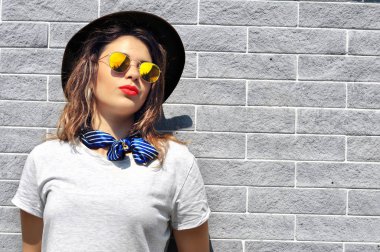 Yaz şehir vibes. Güneşli yaşam tarzı moda portre genç ve güzel kadın moda kıyafet güneş gözlüğü kırmızı ruj gri arka plan üzerinde var  