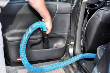 Adam elektrikli süpürge ile arabanın iç temizlik