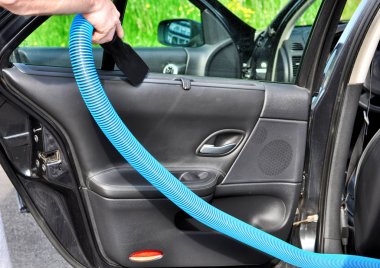 Adam elektrikli süpürge ile arabanın iç temizlik