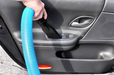 Adam elektrikli süpürge ile arabanın iç temizlik