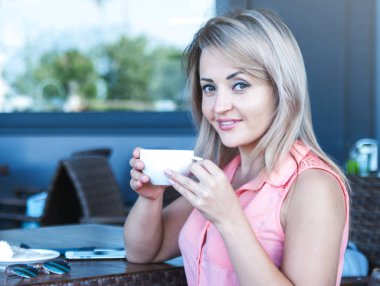 Güzel kadın içecekler kahve açık. 