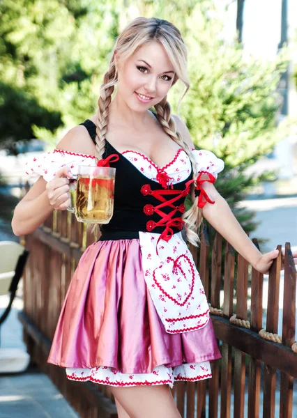 Gülümseyen bira Octoberfest elbiseli sarışın kadın. 