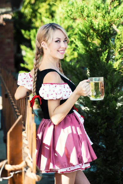 Gülümseyen bira Octoberfest elbiseli sarışın kadın. 