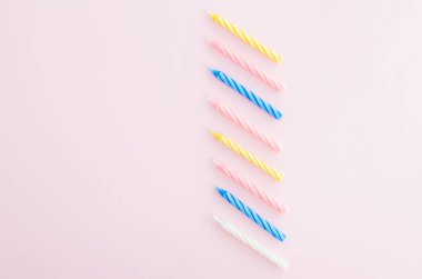 Sarı arka plan üzerinde renkli mumlar. 