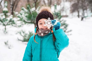 Sevimli küçük kız karda açık oynar.