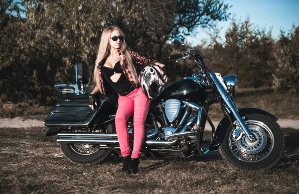 Beautiful woman posing on motorcycle outdoor.