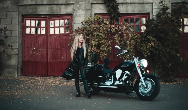 美丽的金发碧眼的女人摆在户外与她的摩托车 — 图库照片
