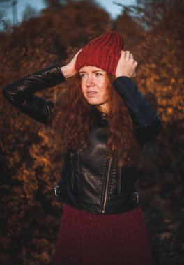 Gülümseyen hat açık kızıl saçlı kadın.