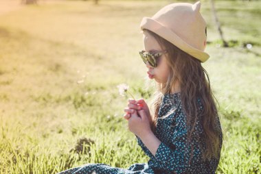 Küçük sevimli kız bir danfelion ile poz. Merhaba bahar.