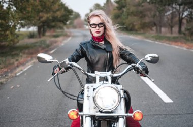 Açık yol üzerinde motosiklet ile poz güzel motorcu kadın. 