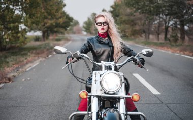 Açık yol üzerinde motosiklet ile poz güzel motorcu kadın.