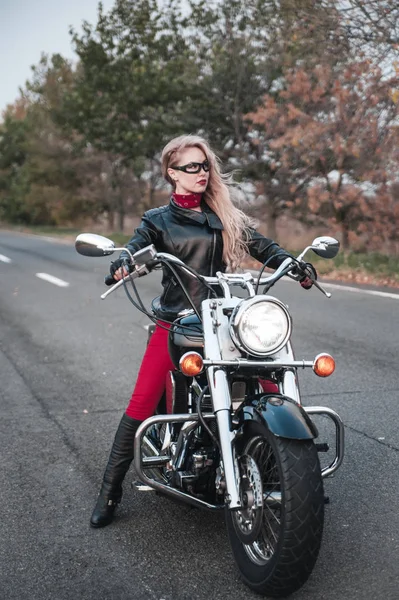美しいバイクに乗る女性がオートバイの道路上で屋外ポーズ — ストック写真
