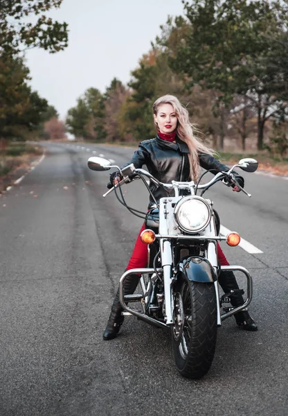 美しいバイクに乗る女性がオートバイの道路上で屋外ポーズ — ストック写真