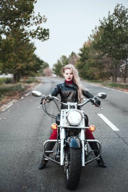 Açık yol üzerinde motosiklet ile poz güzel motorcu kadın. 