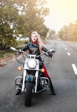 Açık yol üzerinde motosiklet ile poz güzel motorcu kadın. 